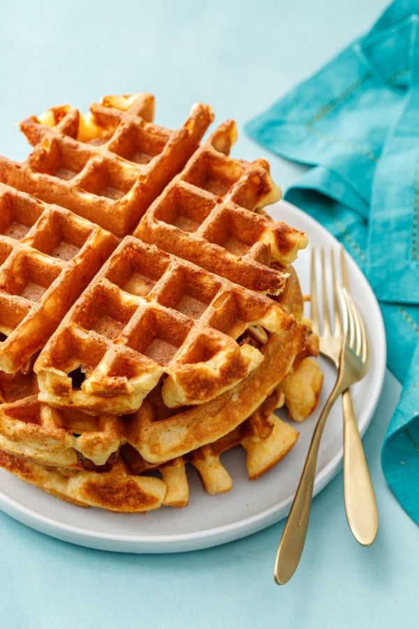 a stack of waffles sitting on top of a white plate next to a fork