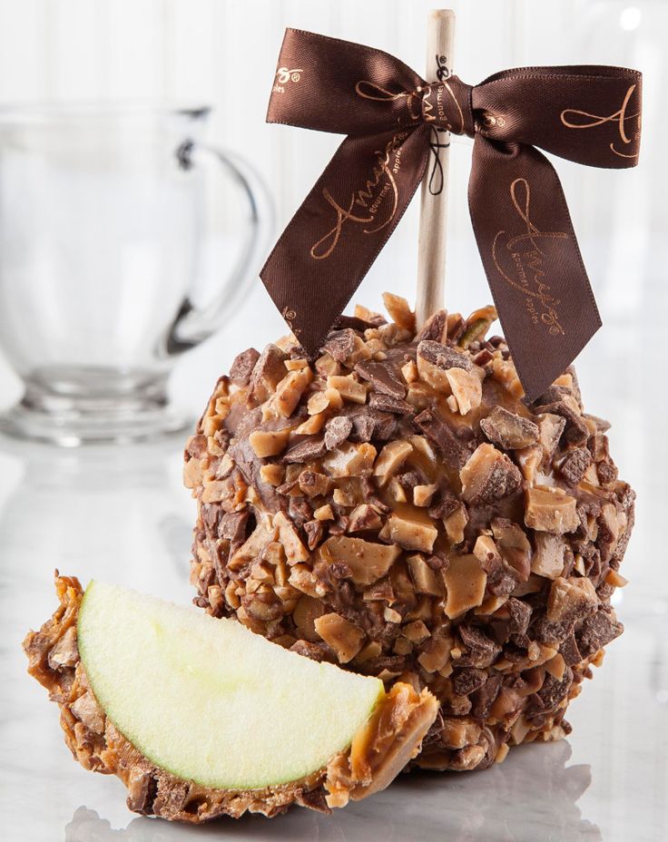 an apple with chocolate and nuts on it