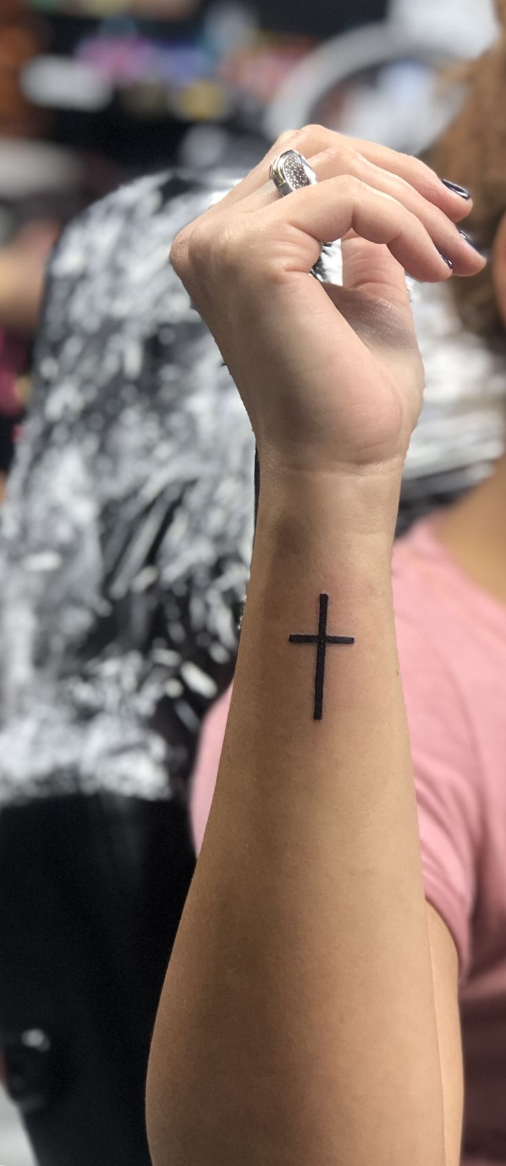 a woman with a small cross tattoo on her wrist