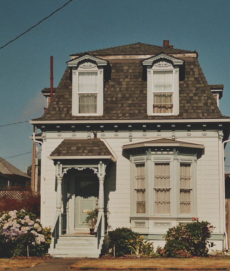 a white house sitting on the corner of a street