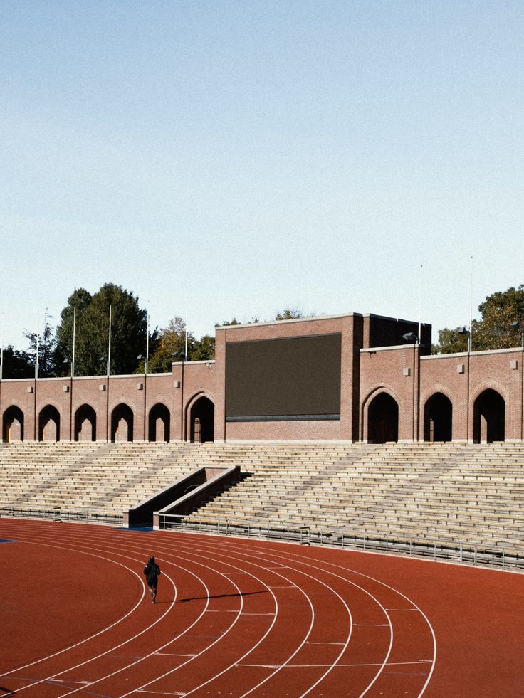 a man running on a track in front of an empty stadium