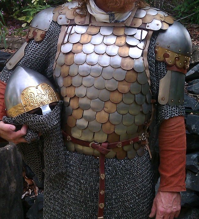 a man dressed in armor holding two helmets