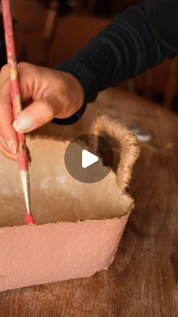 a person holding a pencil in front of a cake