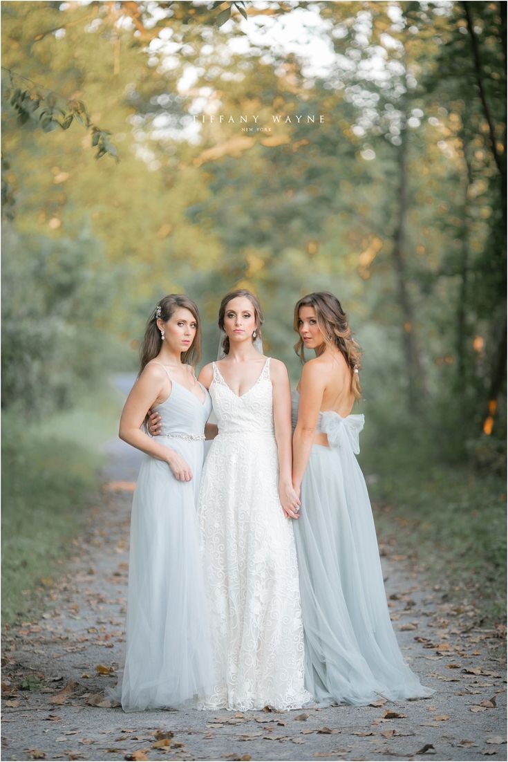 three bridesmaids posing for a photo in the woods