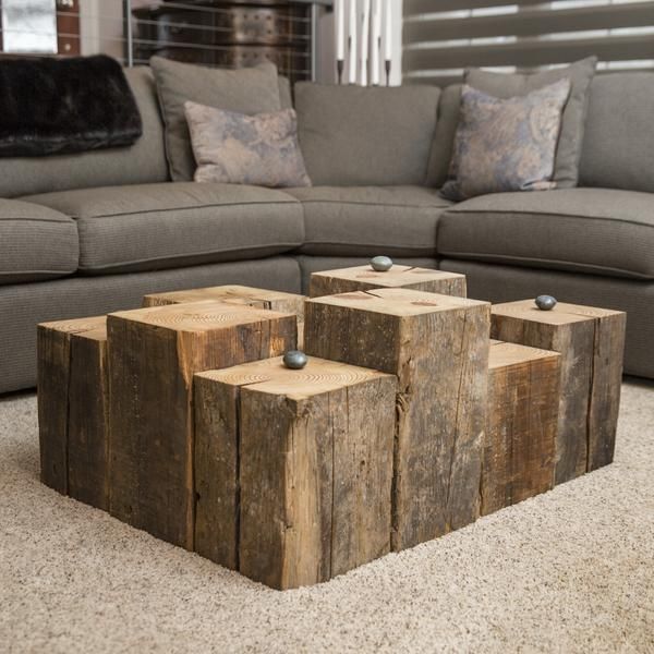 a couch and table made out of wooden blocks in a living room with carpeted flooring