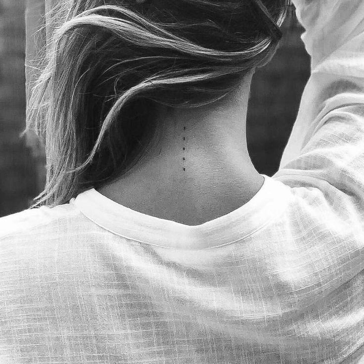 the back of a woman's neck, with her hair blowing in the wind