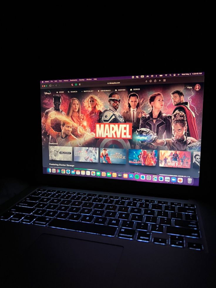 an open laptop computer sitting on top of a black table with the screen lit up