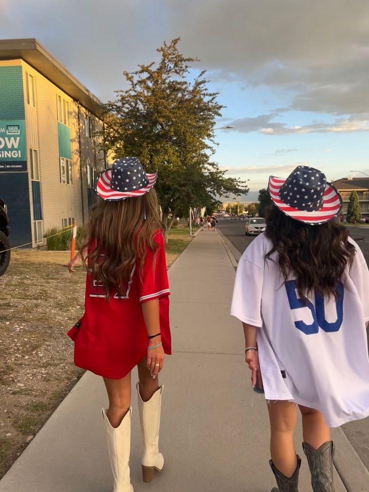 two girls walking down the sidewalk wearing patriotic hats