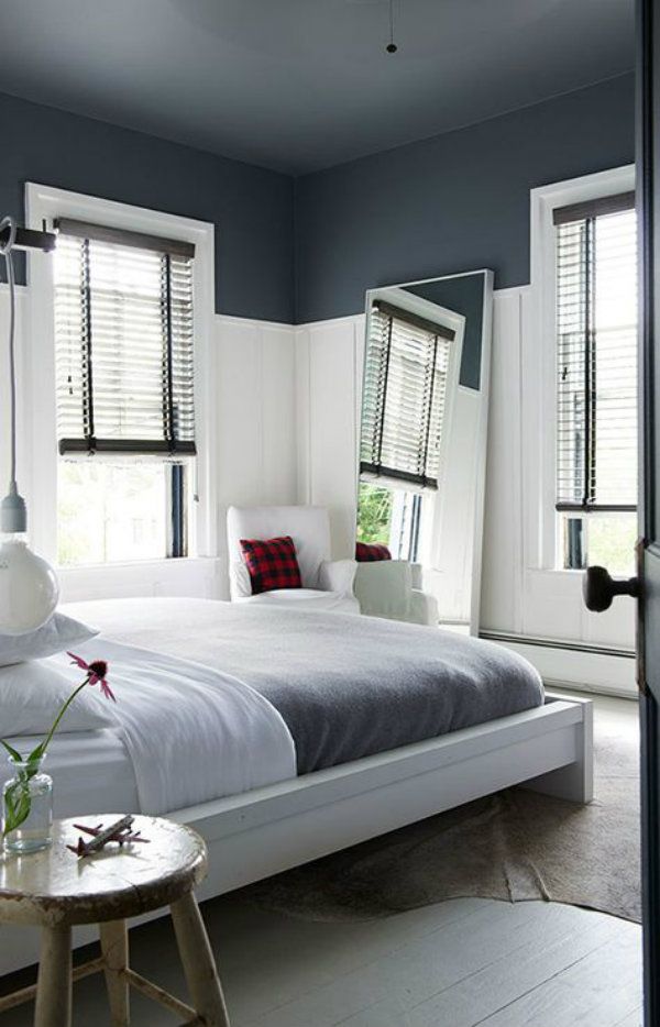 a white bed sitting next to two windows in a bedroom