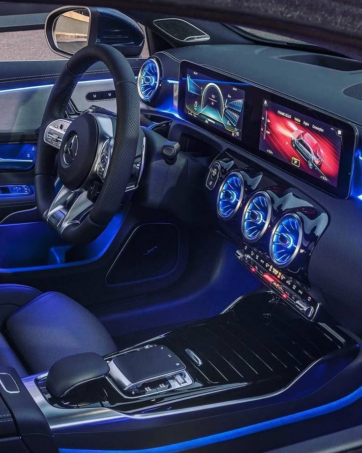 the interior of a car with blue lights and steering wheel, dash board, and touch screen