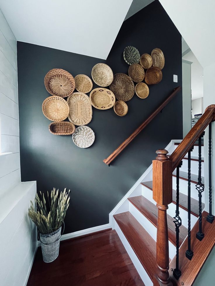 a staircase with baskets on the wall and wooden handrails