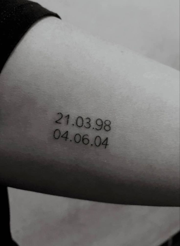 a woman's arm with a date tattoo on it