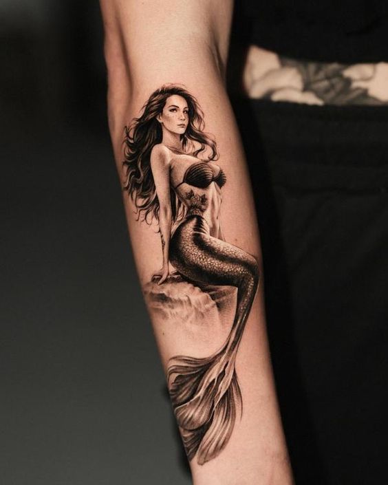 a woman with a mermaid tattoo on her arm