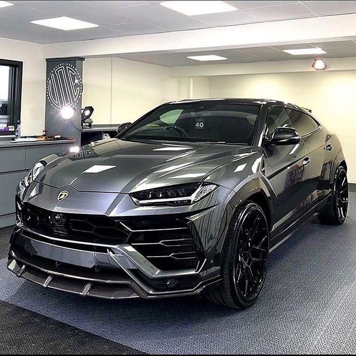 a grey lamb suv parked in a showroom