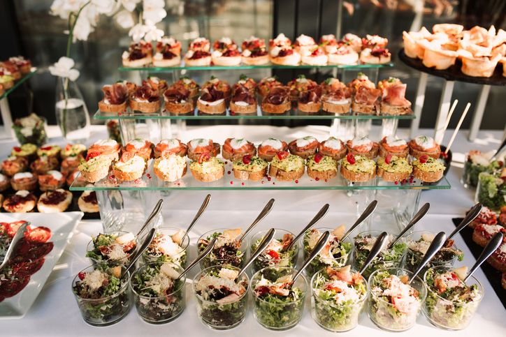 a table topped with lots of different types of food on top of glass trays