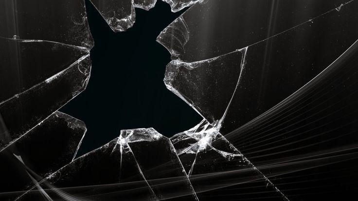 a broken glass window with light coming through it and the image is black and white