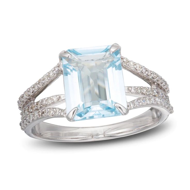 an aqua blue topazte and diamond ring with white diamonds on the sides, set in