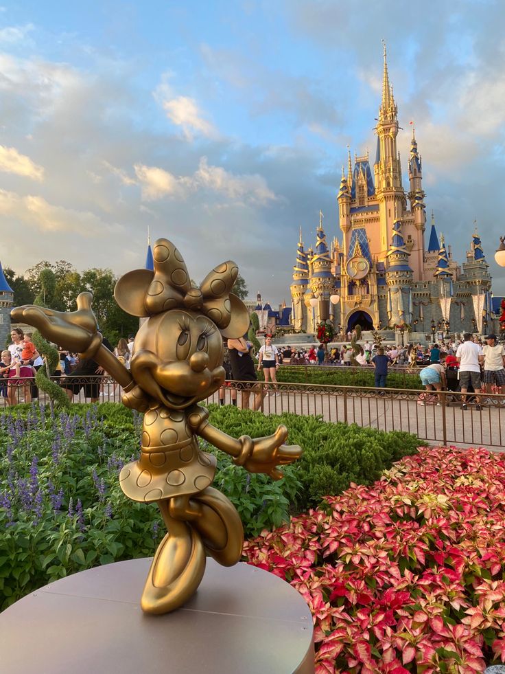 there is a statue of mickey mouse in front of the castle