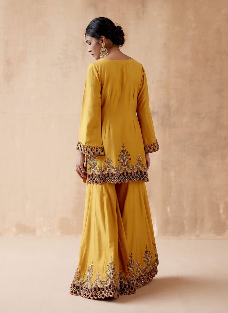 Editor's Note Presenting a luxurious mustard kurta sharara adorned with intricate floral thread embroidery, elegantly highlighted with velvet patchwork and various embellishments. This opulent ensemble is paired with an embroidered dupatta, creating a regal and elegant look perfect for special occasions or festive gatherings. The combination of the rich mustard color, the velvet details, and the ornate embroidery on both the kurta sharara and dupatta adds a touch of grandeur, making this outfit Luxury Kundan Anarkali Kurta, Luxury Designer Wear Slub Silk Sharara, Sharara Suit Pakistani, Marriage Suit, Embroidery Kurta, Velvet Patchwork, Kurta Sharara Set, Satin Suit, Kurta Sharara