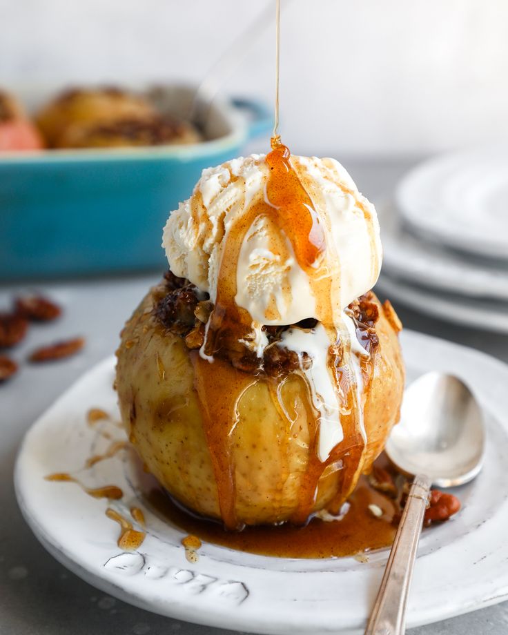 an ice cream sundae with caramel drizzle and pecans on the side