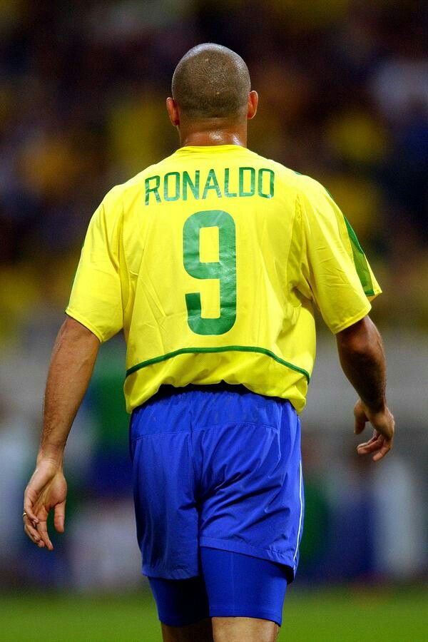 a male soccer player in a yellow shirt and blue shorts is on the field during a game