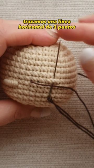 someone is holding a small ball of yarn