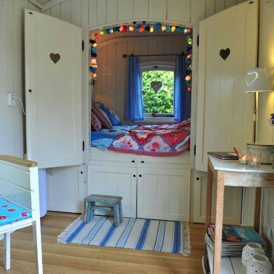 a room with a bed, desk and chair in it that is decorated with lights