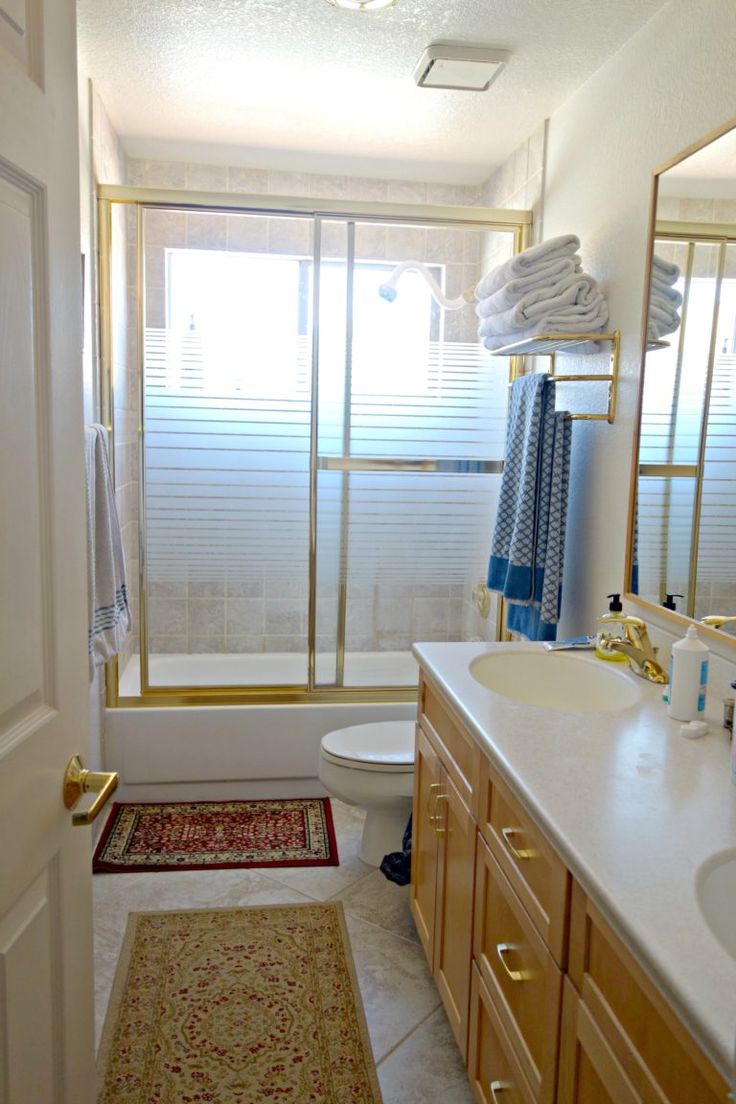 a bathroom with a sink, toilet and bathtub next to a large window in it