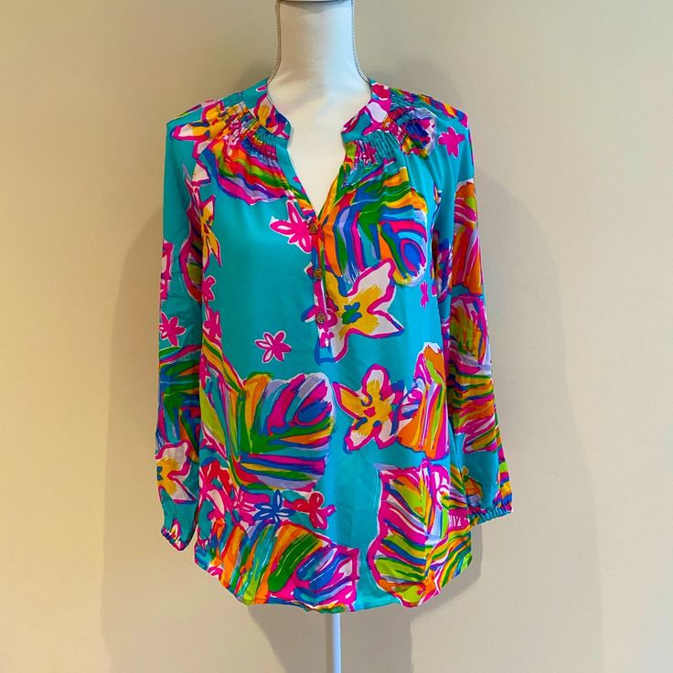 This Lilly Pulitzer Blouse Is Brand New With Tags. It Has Long Sleeves And Gold Buttons On The Front. Spring Holiday Blouse, Casual Spring Holiday Blouse, Multicolor Long Sleeve Summer Blouse, Vibrant Print Blouse For Vacation, Vibrant Print Blouse For Brunch, Multicolor Printed Tops For Holiday, Chic Split Neck Blouse For Vacation, Chic Holiday Tops For Spring, Summer Long Sleeve Blouse With Vibrant Print