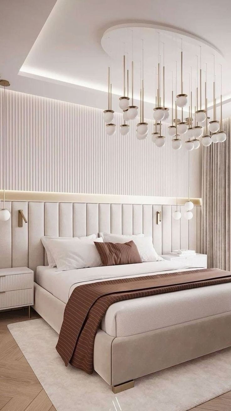 a bedroom with a large bed and chandelier hanging from the ceiling