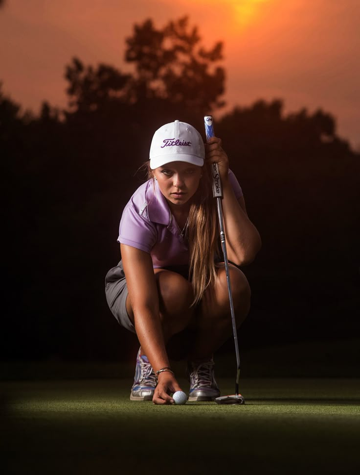 a woman kneeling down with a golf club in her hand