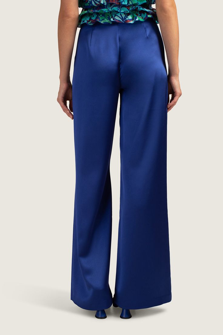 These sleek, wide-leg pants are streamlined, elegant, and colorfully bold. In a rich blue color, these drapey, blue satin pants are sure to be a standout for any occasion. Pair these wide-leg satin pants with a colorful blouse for a complete look, perfect for elegant soirées or spontaneous getaways. Flat front Wide-leg pant Side zipper Full-length inseam Inseam: 31.5" Runs true to size Model is 5'10", wearing size 2 See Women's Size Guide FABRIC: Silverlake Satin 100% Polyester Dry clean only Im Blue Satin Pants, Majorelle Blue, Colorful Blouse, Colorful Blouses, Satin Pants, Blue Satin, Trina Turk, Side Zipper, Leg Pants