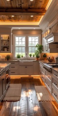 a large kitchen with wooden floors and white cabinetry is lit by recessed lights