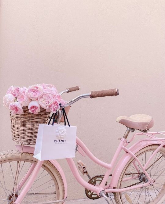 a pink bicycle with flowers in the basket