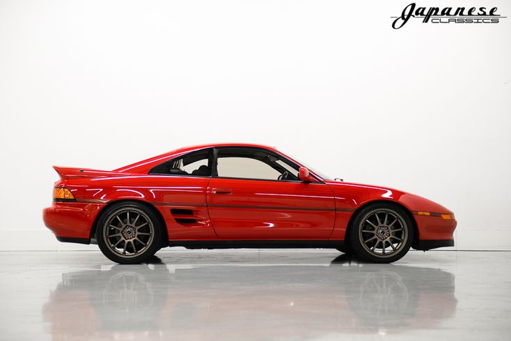 a red sports car parked in a white room