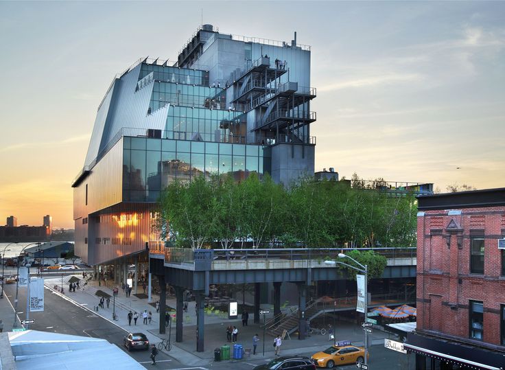 a large building with many windows and people walking on the sidewalk in front of it