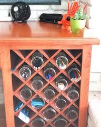 a wooden cabinet filled with glass jars and pencils