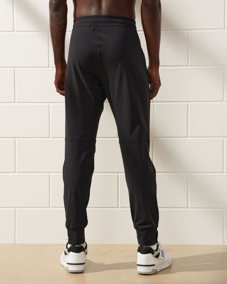 Our new slim-fitting training joggers in a high stretch, quick-dry fabric, that's super soft and breathable with 4-way stretch, anti-abrasion and moisture-wicking properties, and a tapered fit, with room through the thighs and seat and tapered through the calf with cuff bottom. Features an elasticated waistband with exterior drawcords, laser-cut ventilation at knees, side pockets with hidden zipper pocket for extra security and zippers at cuffs. Perfect for all workouts, but clean enough to prov Moisture-wicking Elastane Sportswear Pants, Casual Elastane Activewear For Training, Sportswear Bottoms With 4-way Stretch, Moisture-wicking 4-way Stretch Sportswear Bottoms, Athleisure Elastane Pants With Moisture-wicking, Sporty Elastane Pants For Sports, Athleisure Moisture-wicking Elastane Pants, Sports Bottoms With Go-dry High Stretch, Functional Elastane Bottoms For Sports