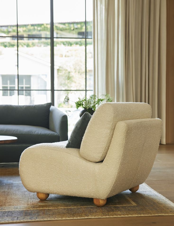 a living room with two couches and a rug in front of a window that looks out onto the outdoors