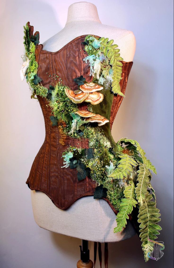 a mannequin made out of wood with plants and mushrooms on it's back