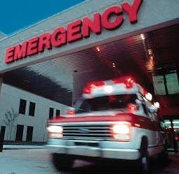 an ambulance is parked in front of the emergency department's main building at night