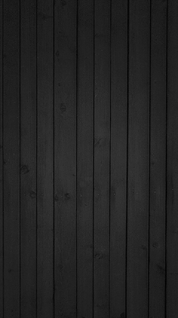 a black wall with wood paneling in the background