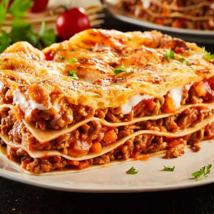 a stack of lasagna casserole sitting on top of a white plate