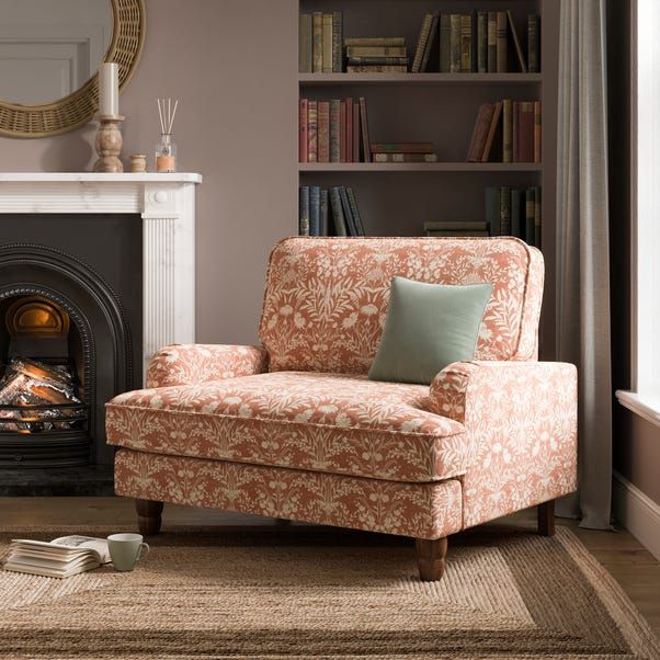 a living room with a fire place and a chair in front of a book shelf