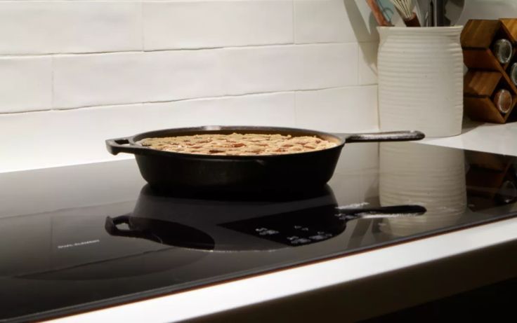 a skillet sitting on top of a stove with food cooking in it's pan