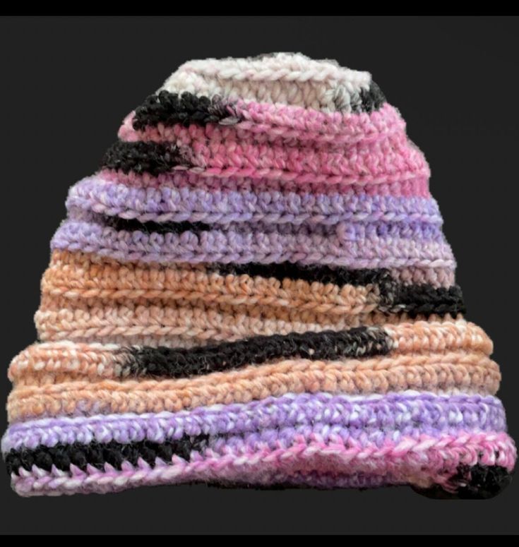 a multicolored crocheted hat is laying on top of each other,