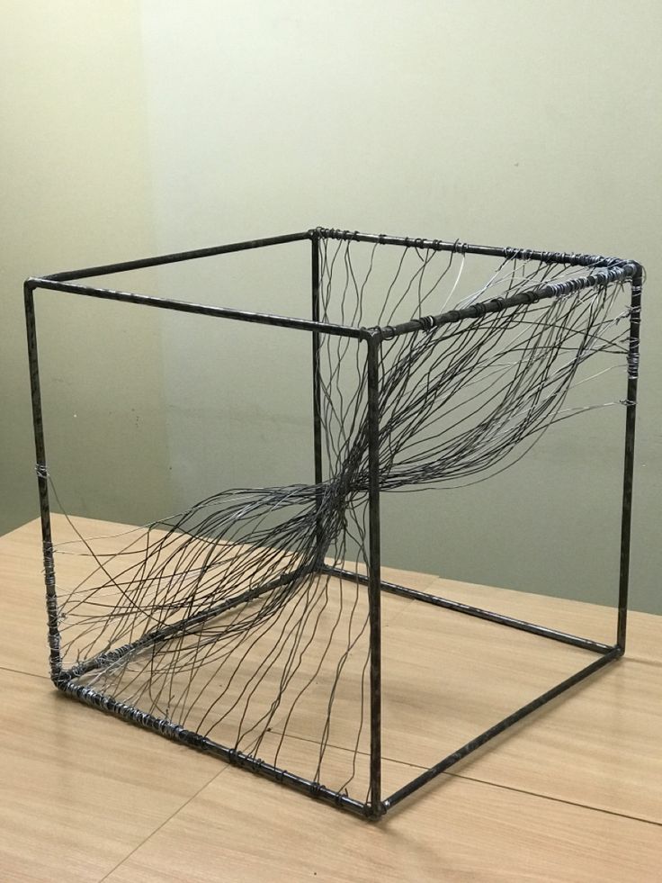 a sculpture made out of wires sitting on top of a wooden table