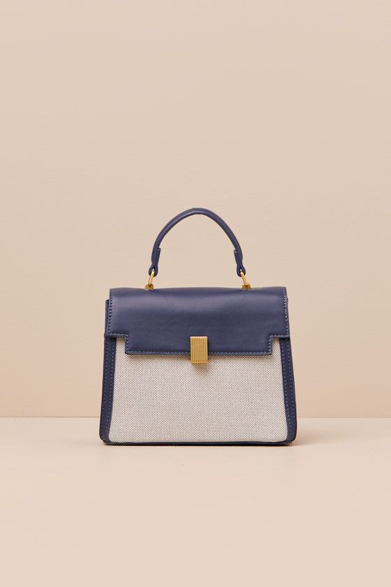 A considered cutie like you will find a million ways to style the Poised Intention Navy and White Handbag! Sleek faux leather shapes this stylish bag that has a flat bottom and a satchel-inspired silhouette with woven panels at the front and back, a flexible top handle, and a top flap with a locking clasp. Roomy interior boasts a zippered sidewall pocket, a second sidewall compartment, and an optional shoulder strap for crossbody wear. Gold-toned hardware throughout. Lined. Bag Measures 8" Wide, Navy Handbag, Navy Purse, White Handbag, Stylish Bag, Business Outfits, Handle Bag, Dublin, Navy And White, Top Handle