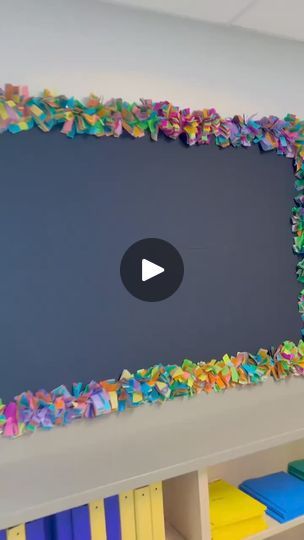 a large black board with colorful streamers on it's side in a classroom