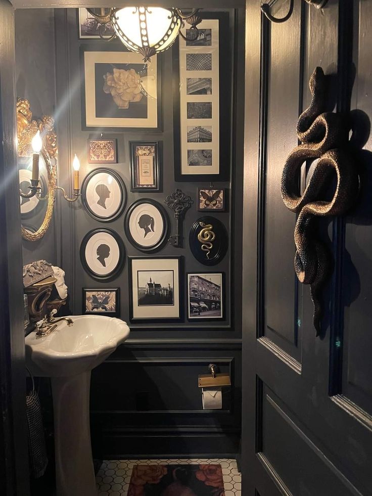 the bathroom is decorated in black and white with pictures on the wall above the sink